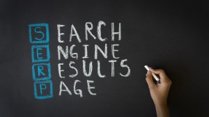 Person drawing a Search Engine Results Page illustration with chalk on a blackboard.